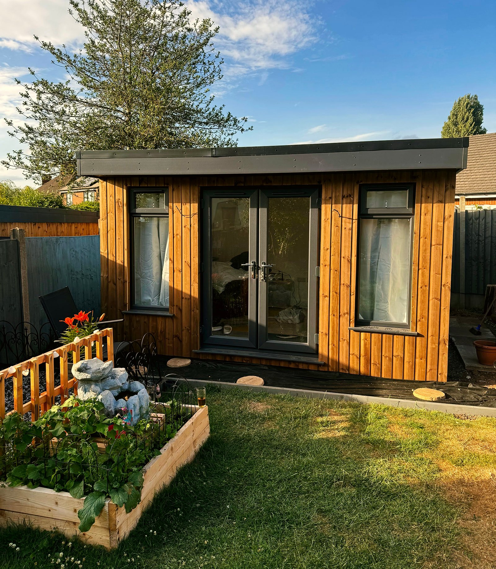 A 3m x 4m timber garden room in daylight with curtains at the windows
